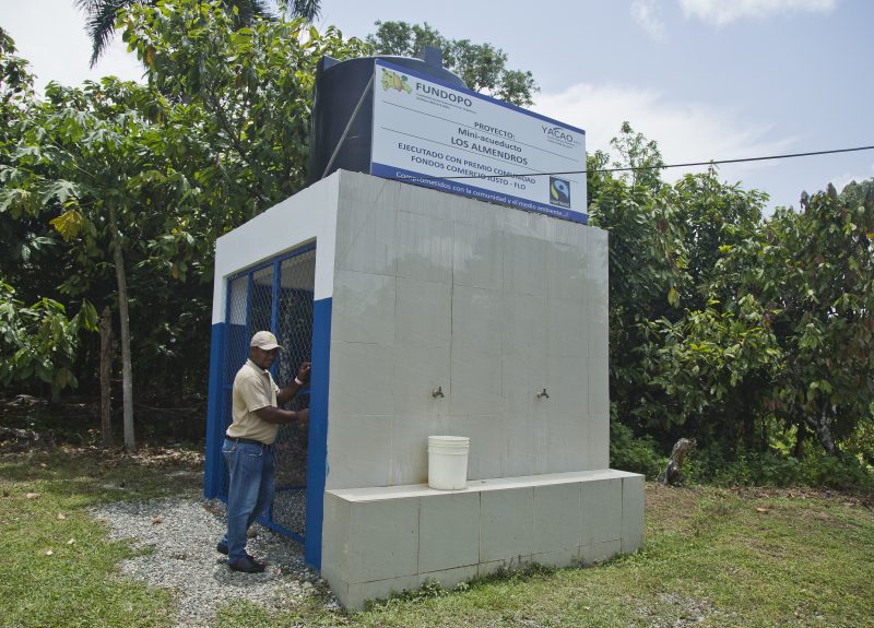 Francisco Contreras Martínez stands just outside of a small, concrete aqueduct.