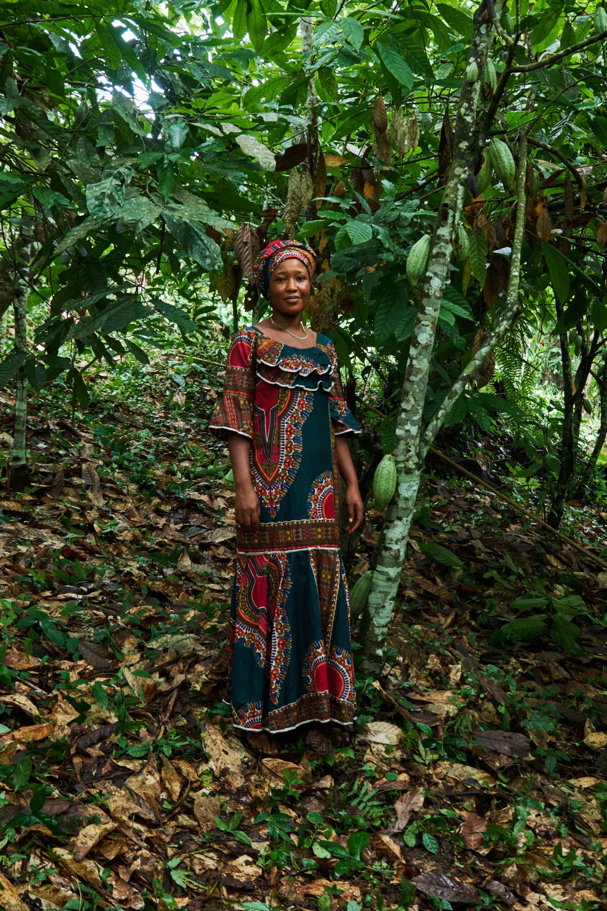 Salamatu Katta poses for a portrait amid the understory shade of cacao trees.