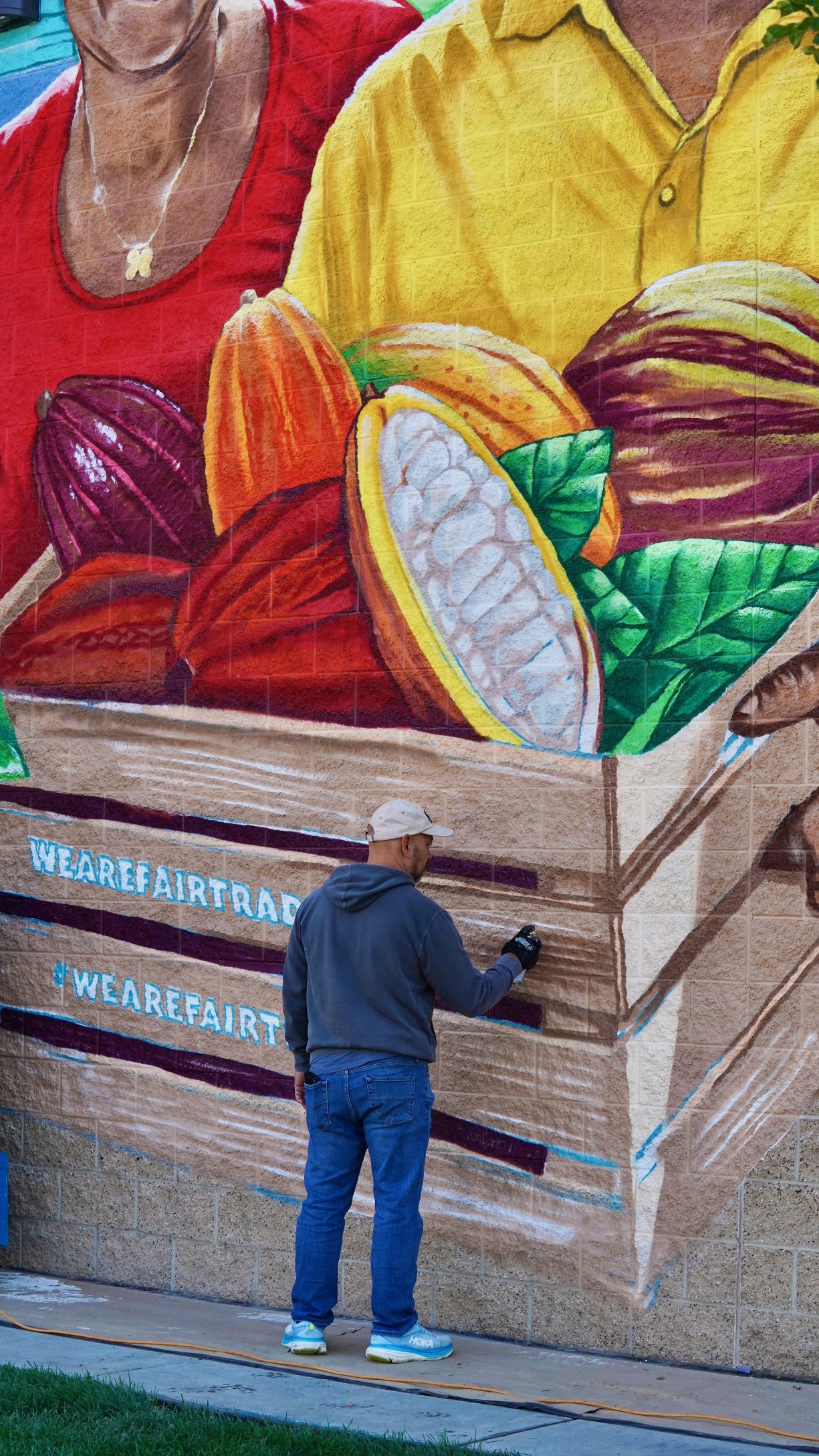 Bobby Gaytan applies finishing detail to his mural, which is about four times his height.