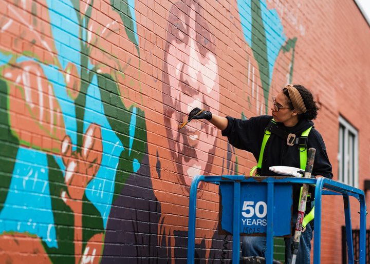 Artist Julia Bottoms paints a farmer mural.