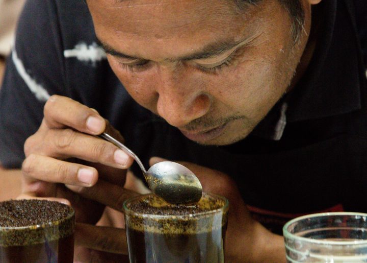 Man sips coffee at a coffee cupping laboratory in Indonesia