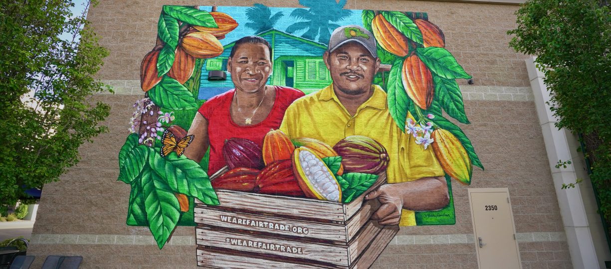 Image of mural depicting sibling cocoa farmers from Dominican Republic with cocoa pods.