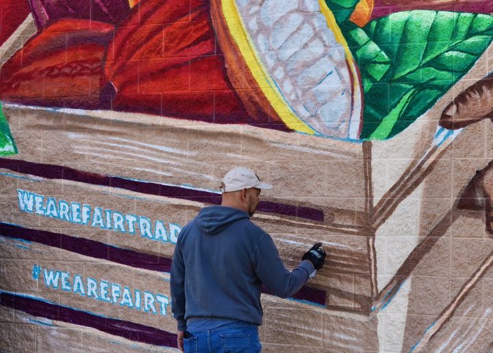 Bobby Gaytan applies finishing detail to his mural, which is about four times his height.