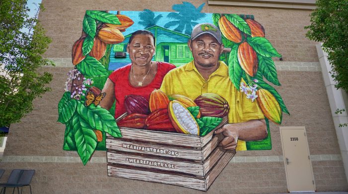 Image of mural depicting sibling cocoa farmers from Dominican Republic with cocoa pods.