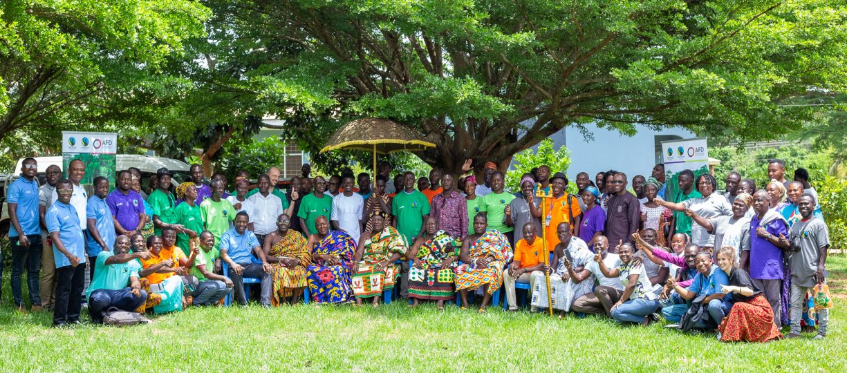 A large group of people participating in Ghana's Agroforestry for Impact project smile at the camera.