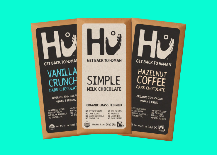 Three Fairtrade, organic chocolate bars from Hu Kitchen. The flavors are vanilla crunch dark chocolate, simple milk chocolate, and hazelnut coffee dark chocolate.