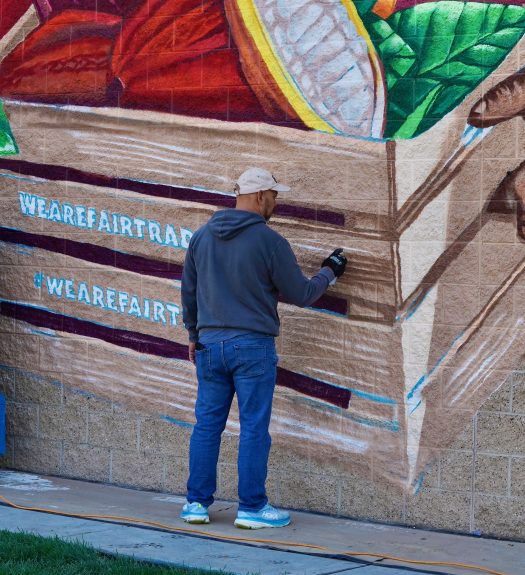 Bobby Gaytan applies finishing detail to his mural, which is about four times his height.